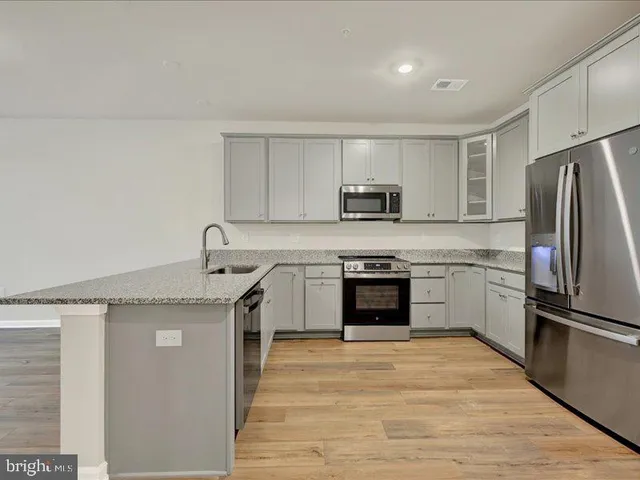 a kitchen with a stove top oven and refrigerator