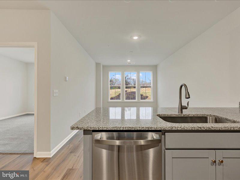4003 Seaside Alder Road, Unit 102 ASTER Bowie, MD 20720 - Photo 9 of 27 a kitchen with granite countertop a sink and cabinets
