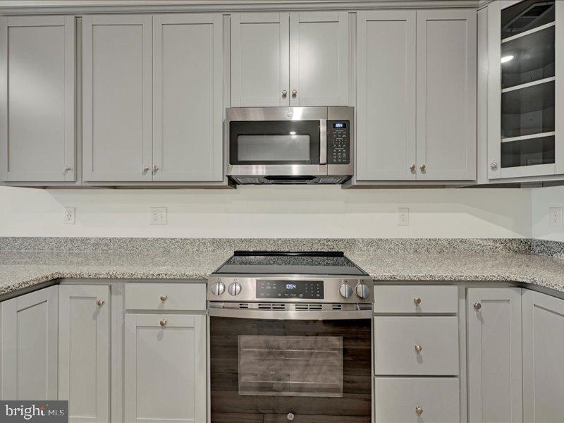 4003 Seaside Alder Road, Unit 102 ASTER Bowie, MD 20720 - Photo 10 of 27 a kitchen with granite countertop white cabinets and stainless steel appliances