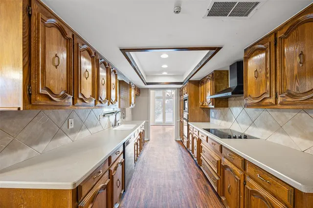 a hallway with couches a stove and a oven with wooden floor