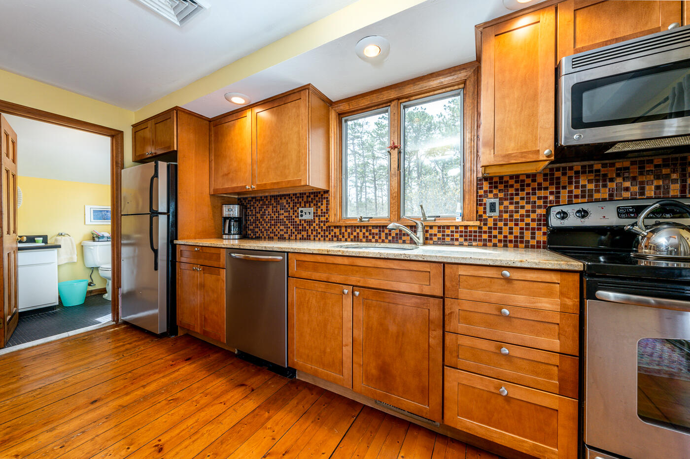 150 Herring Brook Road Eastham, MA 02642 - Photo 14 of 54 a kitchen with stainless steel appliances a sink cabinets and a large window