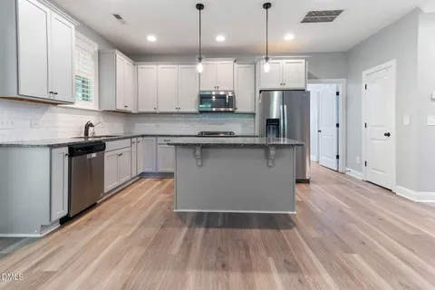 a kitchen with stainless steel appliances granite countertop a sink stove and refrigerator