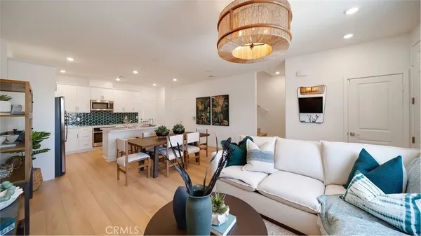 a living room with furniture kitchen view and a large window