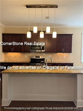 a kitchen with kitchen island granite countertop a refrigerator and a stove