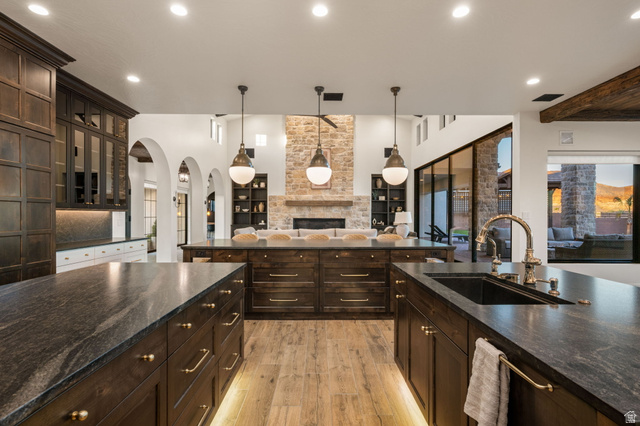 4871 South Homestead Way Washington, UT 84780 - Photo 23 of 151 Kitchen featuring dark wood finish cabinetry, dark stone counters, and a fireplace
