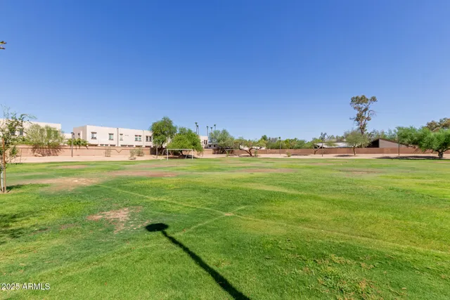 a view of swimming pool with lawn chairs under an umbrella