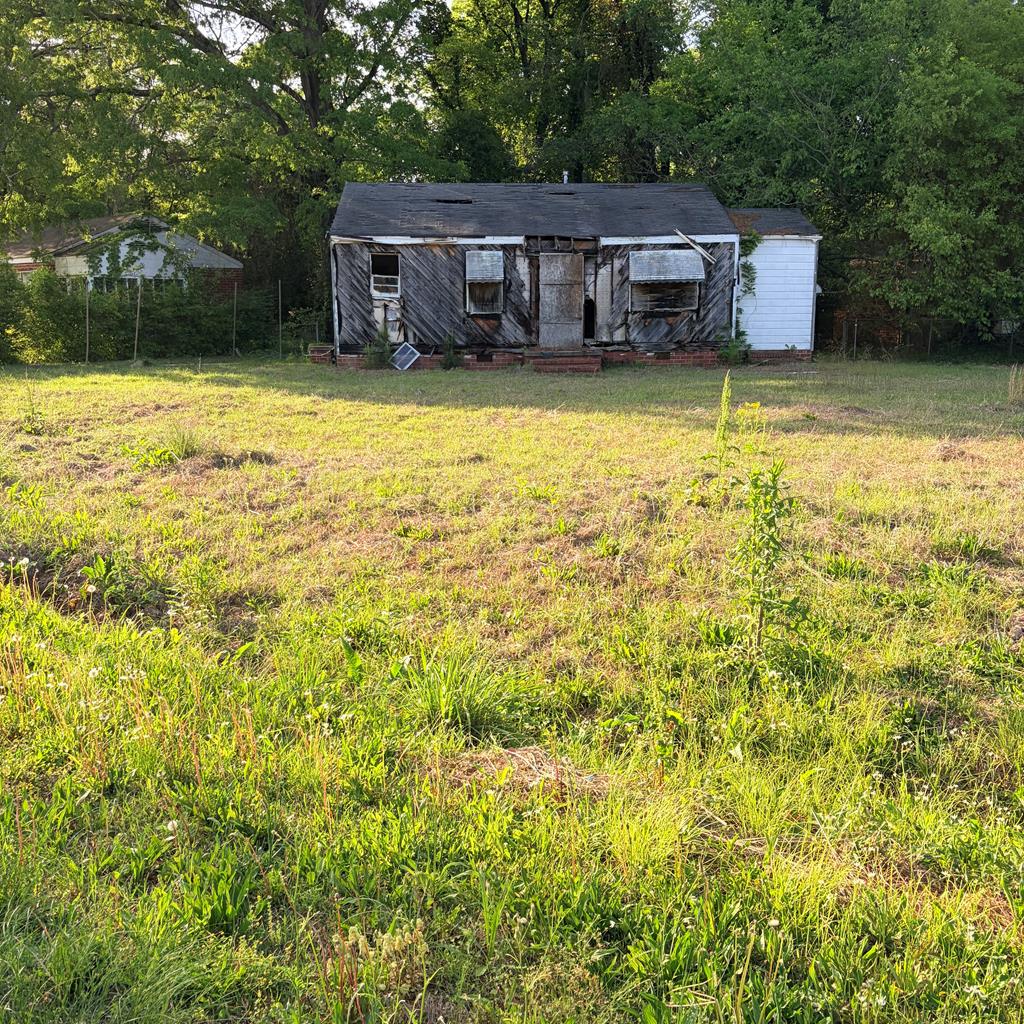 a backyard of a house with yard and large trees