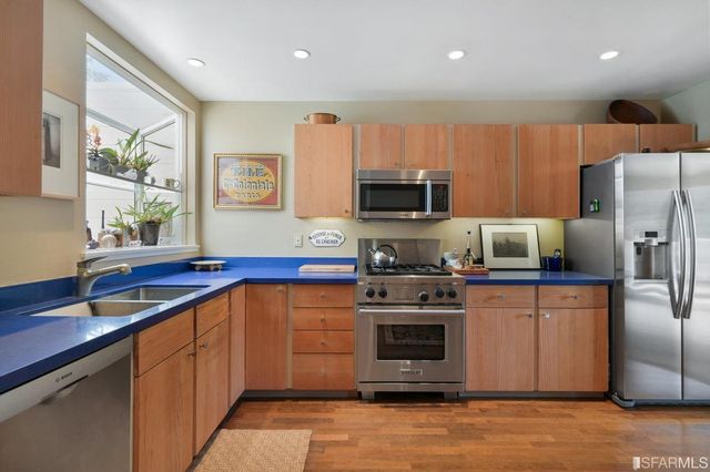 a kitchen with stainless steel appliances a stove sink microwave and refrigerator