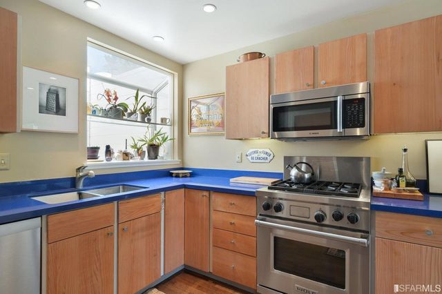 a kitchen with stainless steel appliances a stove a microwave sink and cabinets