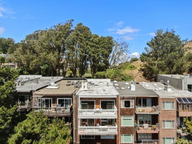 a view of residential houses with cars parked in front of it