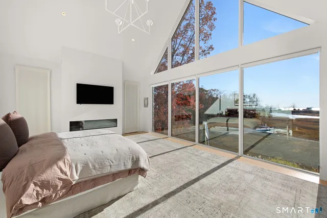 a bedroom with a large bed and a flat tv screen on wall