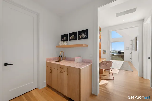 a view of a kitchen from a dining room with wooden floor