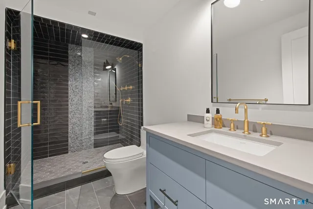 a bathroom with a sink a toilet and shower