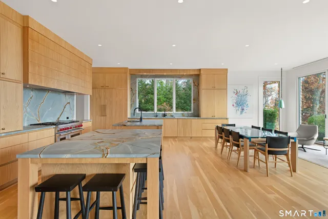 a living room with furniture a dining table and a large window