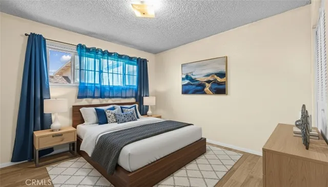 a bedroom with a bed and a dresser next to a window