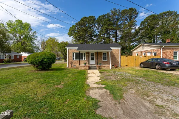 a view of a backyard with wooden fence and a bench