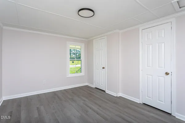 an empty room with a window and wooden floor