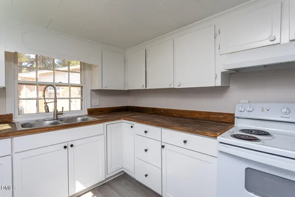 a kitchen with granite countertop white cabinets and white appliances
