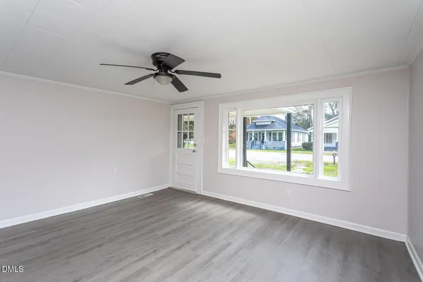 a view of an empty room with wooden floor