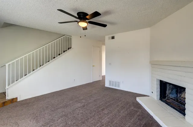 a view of a livingroom with a ceiling fan and fireplace