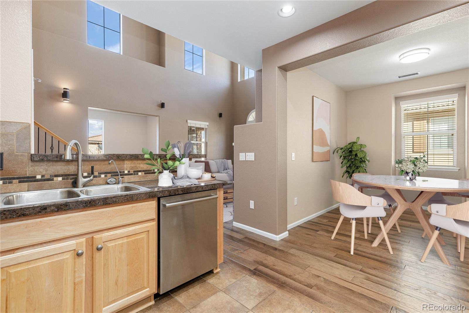 3301 Cascina Circle, Unit C Highlands Ranch, CO 80126 - Photo 12 of 40 a kitchen with stainless steel appliances granite countertop a table chairs sink and cabinets