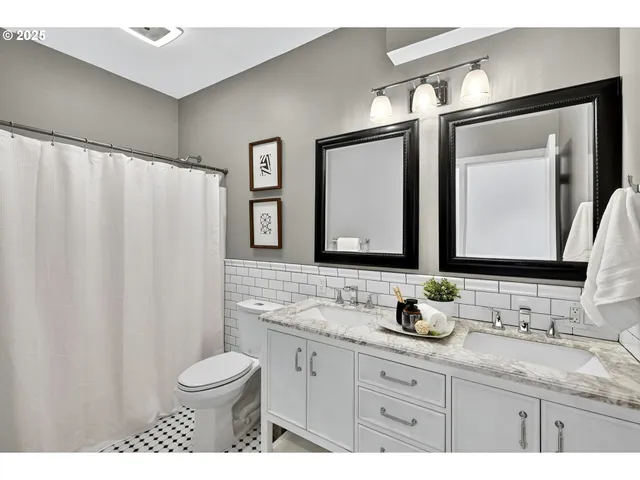 a bathroom with a granite countertop sink a toilet and a mirror