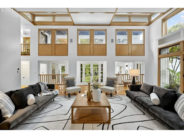 a living room with furniture ceiling fan and a large window
