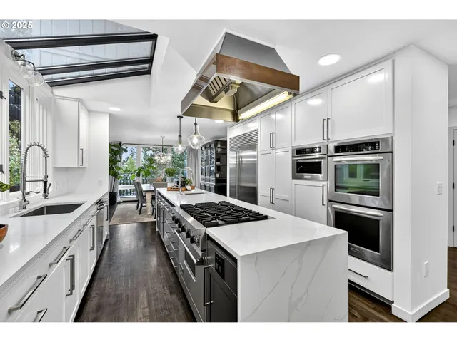 a kitchen with stainless steel appliances kitchen island a stove and a sink