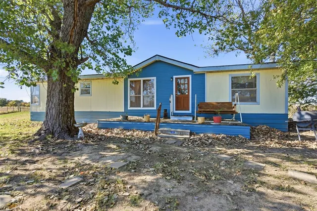 a view of a house with backyard and tree