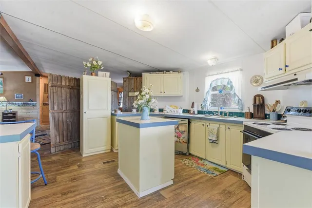 a kitchen with a refrigerator a sink dishwasher with a dining table and chairs
