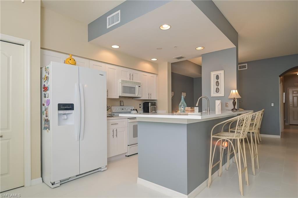8670 Cedar Hammock Circle, Unit 223 Naples, FL 34112 - Photo 11 of 27 a kitchen with appliances a sink and cabinets