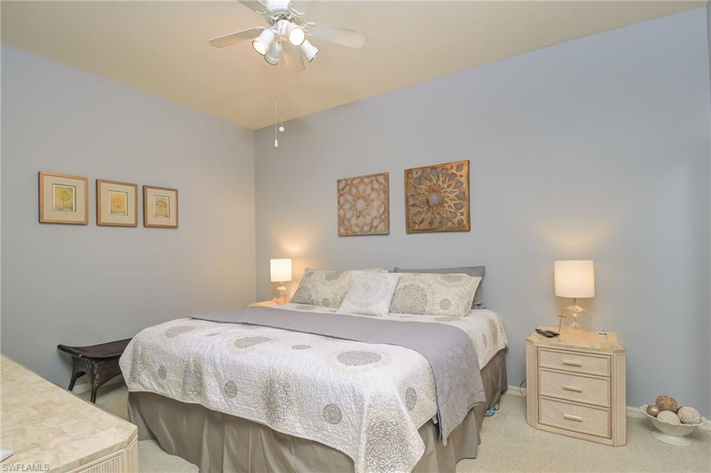 8670 Cedar Hammock Circle, Unit 223 Naples, FL 34112 - Photo 13 of 27 a bedroom with a bed and a chandelier