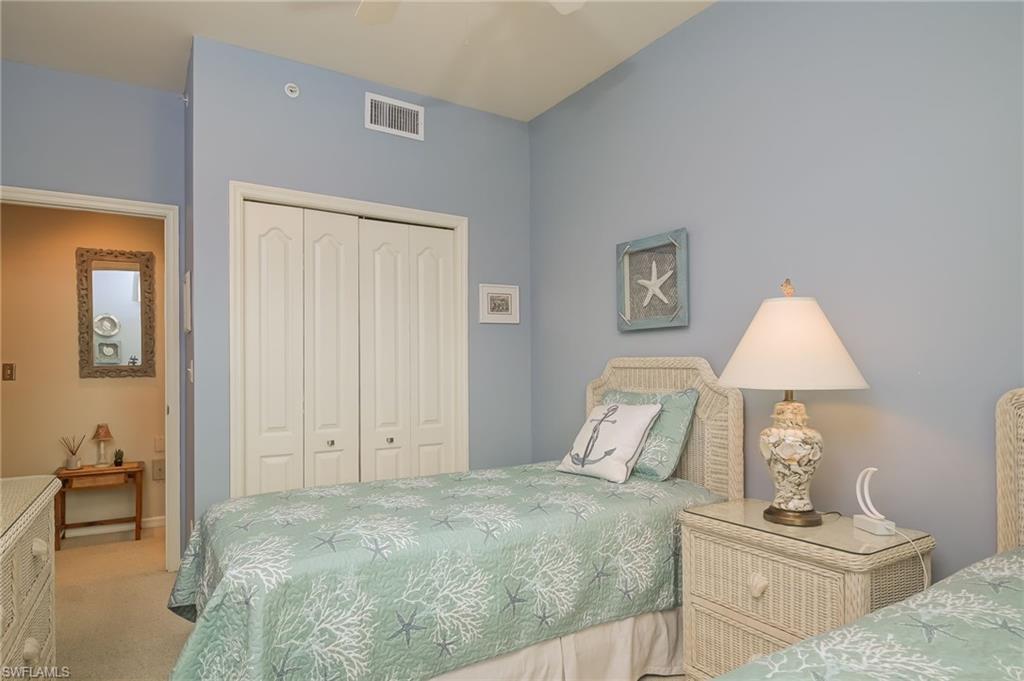 8670 Cedar Hammock Circle, Unit 223 Naples, FL 34112 - Photo 17 of 27 a bedroom with a bed and a lamp on table
