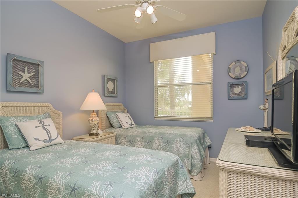 8670 Cedar Hammock Circle, Unit 223 Naples, FL 34112 - Photo 18 of 27 a bedroom with a bed and a chandelier