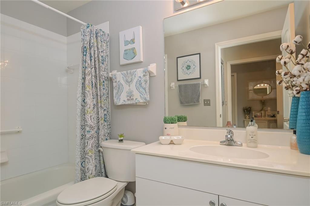 8670 Cedar Hammock Circle, Unit 223 Naples, FL 34112 - Photo 19 of 27 a bathroom with a granite countertop toilet sink and mirror