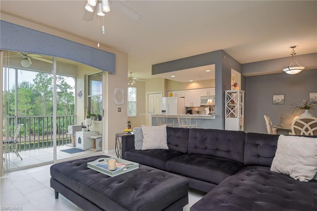 8670 Cedar Hammock Circle, Unit 223 Naples, FL 34112 - Photo 6 of 27 a living room with furniture and a large window