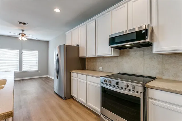 a kitchen with stainless steel appliances a stove a microwave and cabinets