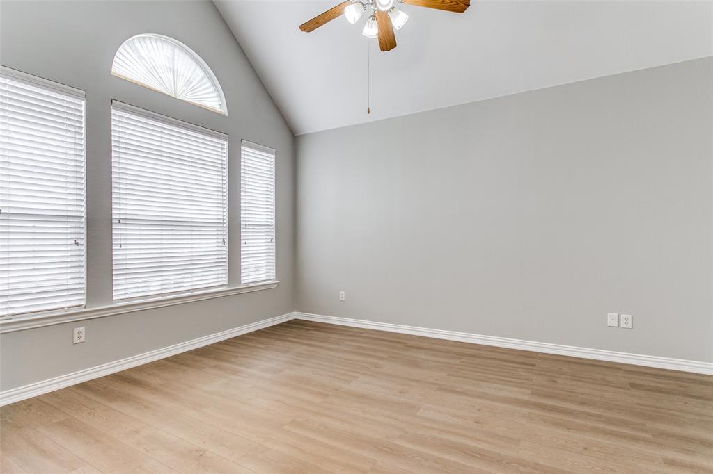 3725 Vienna Street Irving, TX 75038 - Photo 8 of 25 an empty room with wooden floor chandelier fan and windows