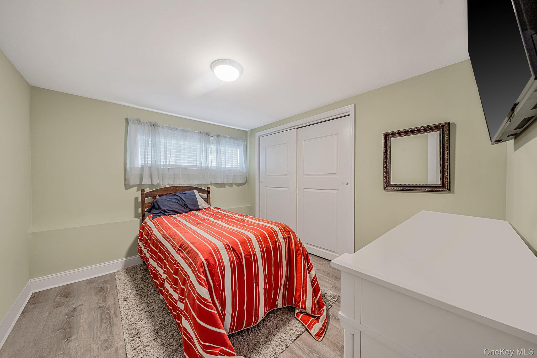 110 Stephen Road Bayport, NY 11705 - Photo 29 of 39 a bedroom with a bed and a flat screen tv