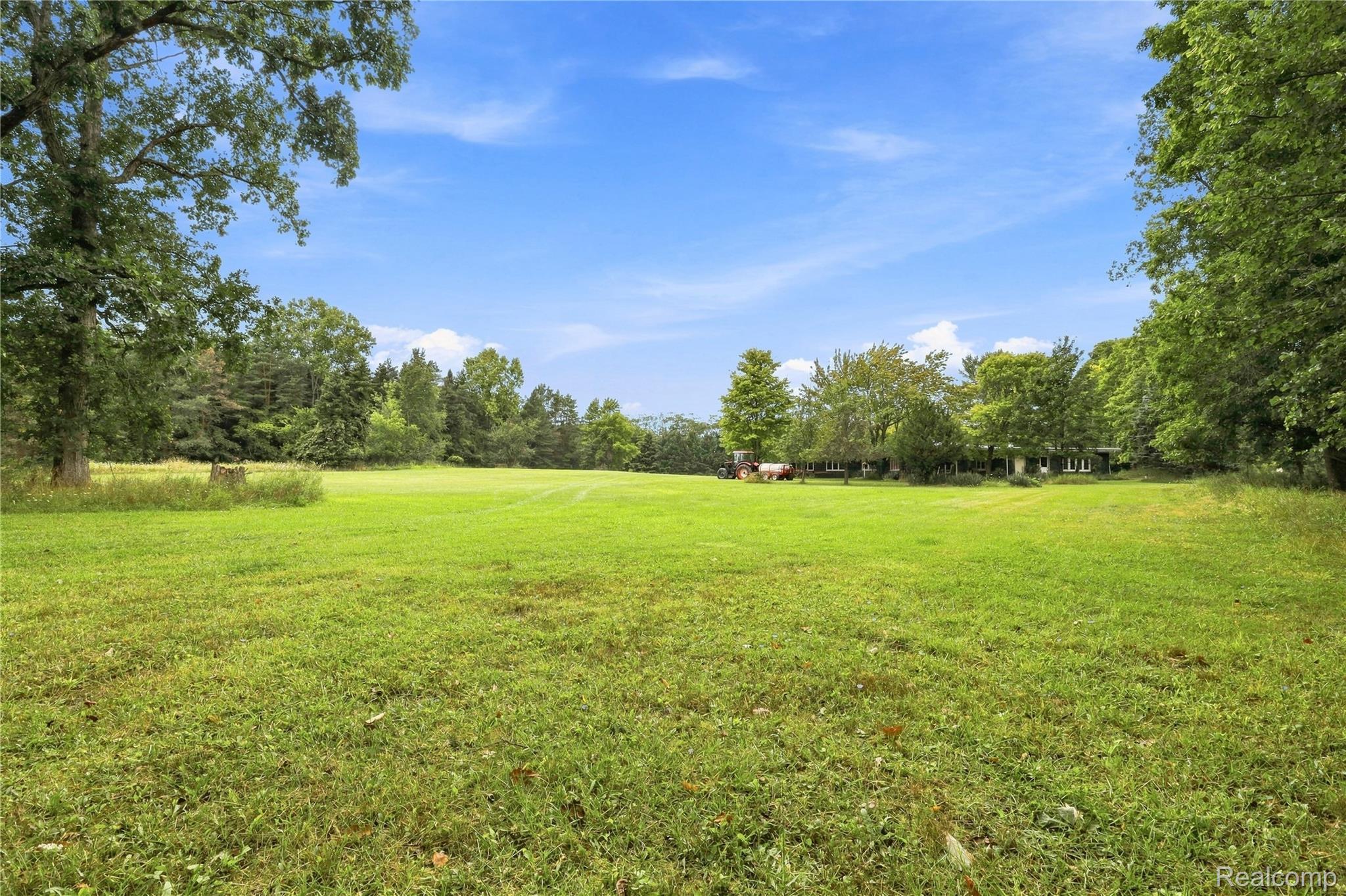 7386 Dean Road Fenton, MI 48430 - Photo 58 of 64 Expansive green space featuring mature trees and a distant structure