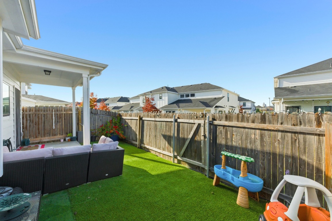 159 Threshing Road, Unit A Buda, TX 78610 - Photo 31 of 33 Fenced backyard featuring an outdoor hangout area, a residential view, and a patio area