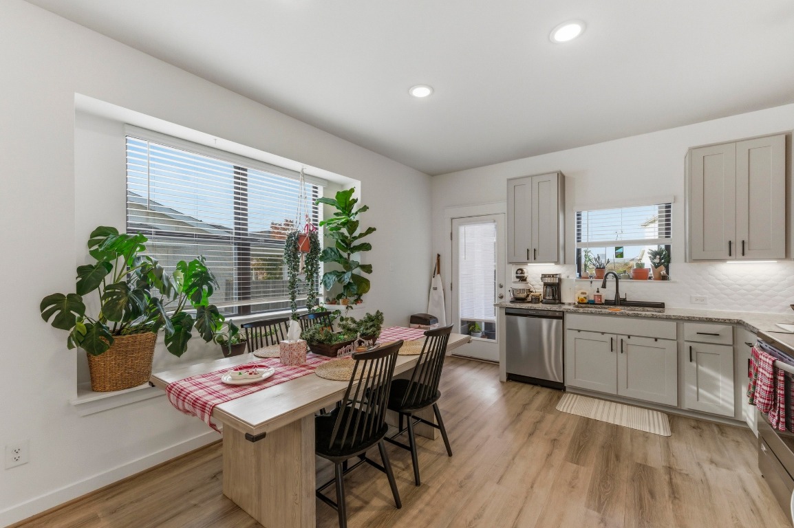 159 Threshing Road, Unit A Buda, TX 78610 - Photo 9 of 33 Kitchen featuring appliances with stainless steel finishes, light wood finished floors, gray cabinets, recessed lighting, and tasteful backsplash