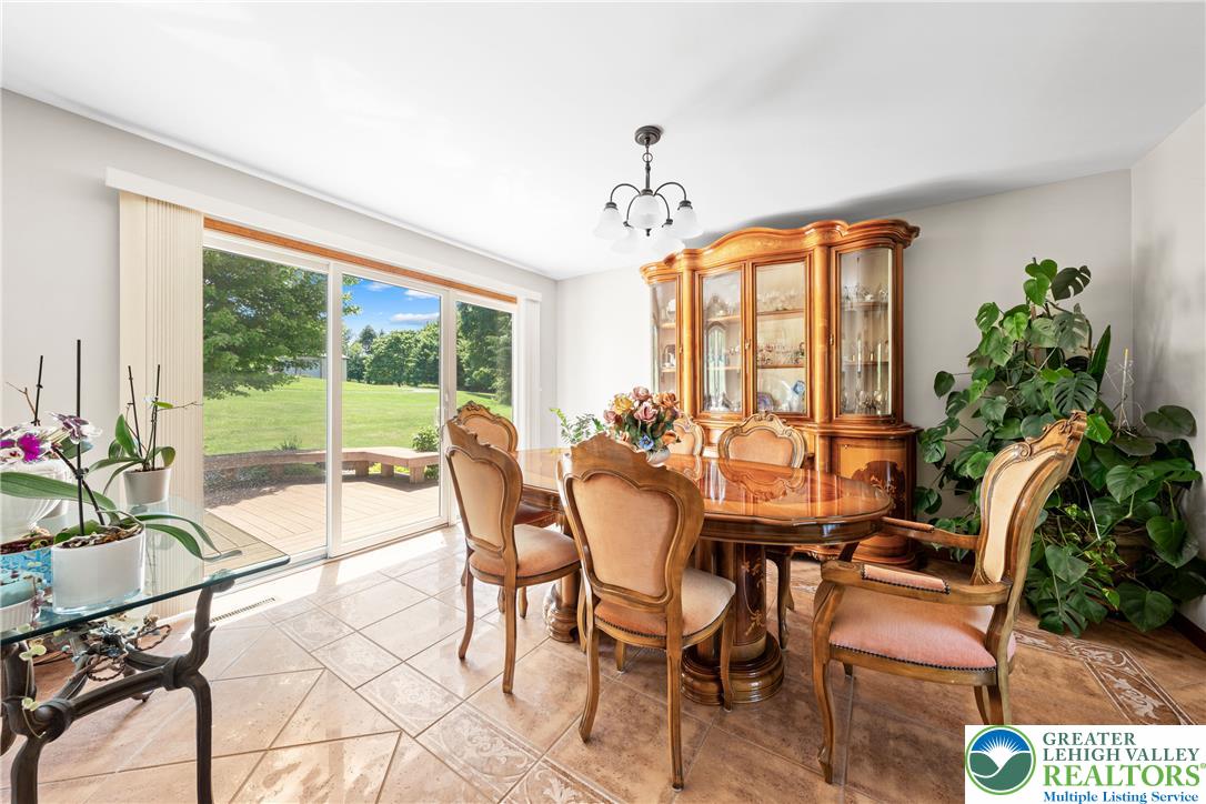 947 Tamenend Road Bath, PA 18014 - Photo 14 of 61 Sliding glass doors offer a panoramic view of the verdant yard, extending the dining space outdoors.