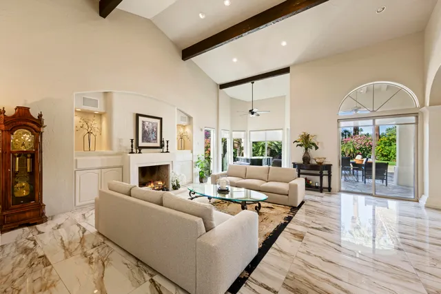 a living room with furniture a fireplace and potted plants