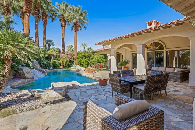 a view of a patio with couches table and chairs and potted plants
