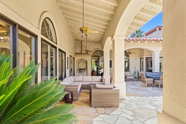 a patio with a table and chairs and potted plants
