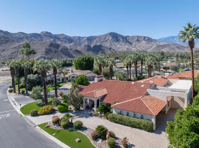 a front view of a house with a yard and potted plants
