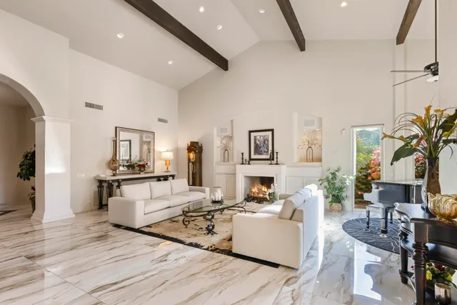 a living room with furniture fireplace and a large window