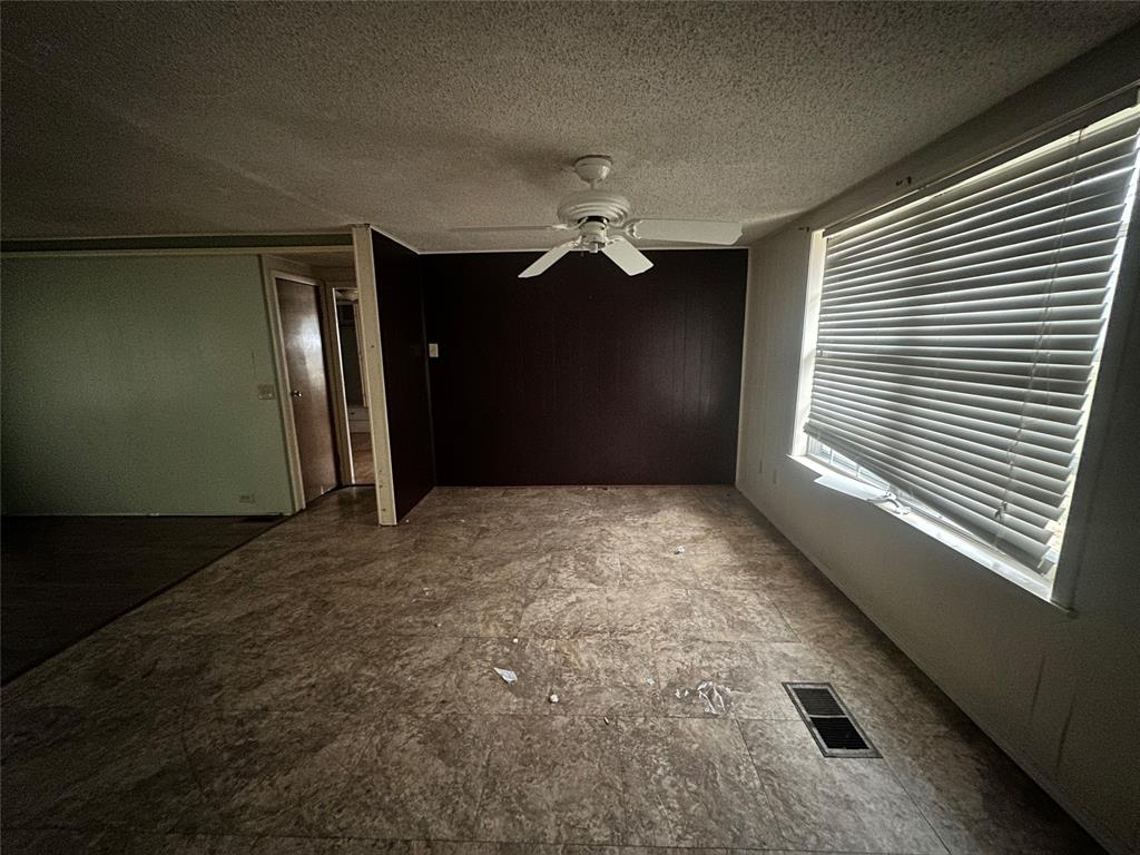 1832 Smokehouse Road Granbury, TX 76049 - Photo 11 of 23 Empty room featuring ceiling fan and a textured ceiling