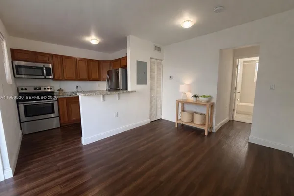 a kitchen with stainless steel appliances wooden floors and view living room